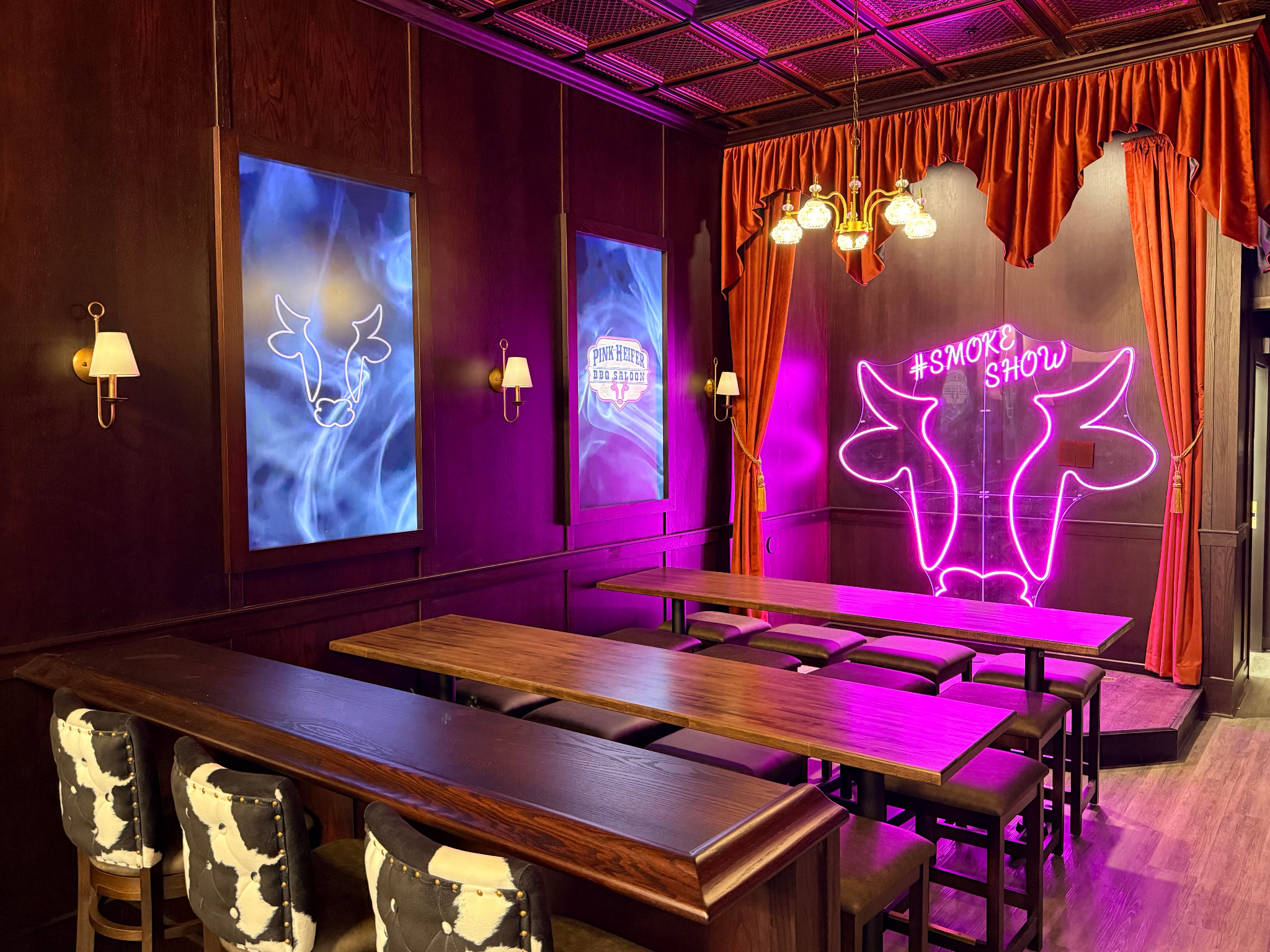 Pink Heifer BBQ Saloon seating and the pink Smoke Show neon sign in Madison