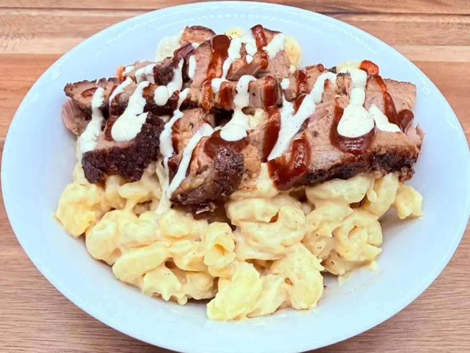 Pink Heifer Mac n’ Cheese Bowl topped with smoked brisket and BBQ sauce